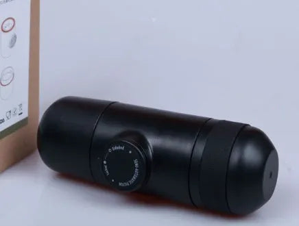 Black portable manual coffee machine showing compact size and manual operation components.