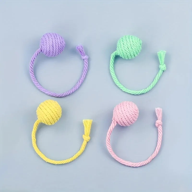 Cat toy ball with rope handle in green, pink, purple or yellow colours with internal bell