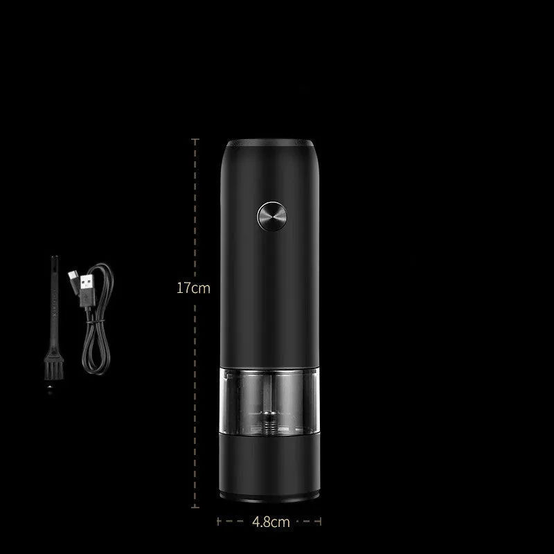 Black and white electric salt and pepper grinder set with USB charging cable on a kitchen worktop.