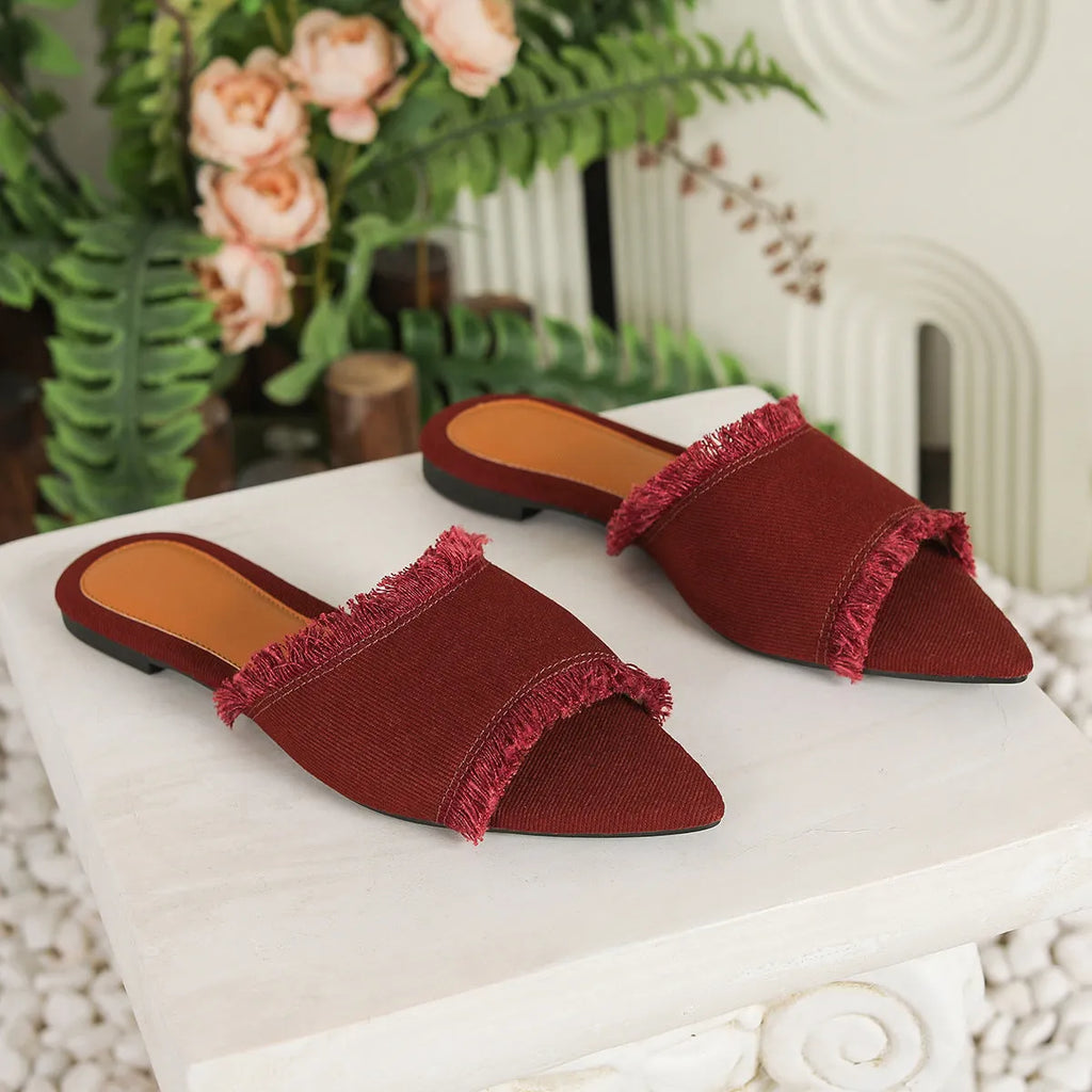 Women's denim flat slipper with tassel detail, leather lining, and a solid colour option.