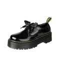 Black and white women's lace-up shoes with a thick sole, cross straps, and ribbon details.