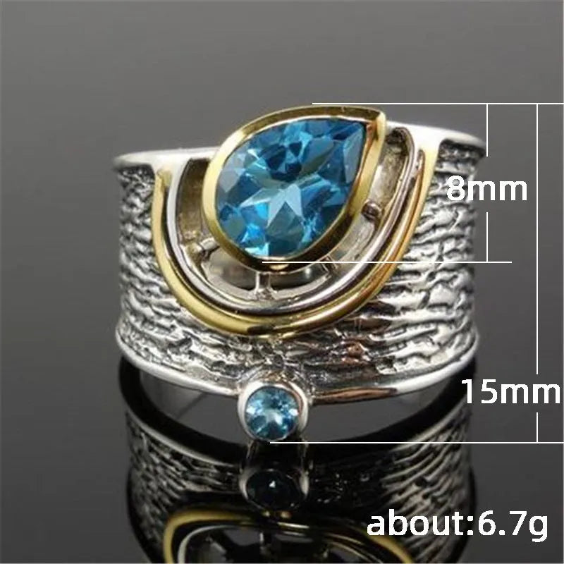 Blue drop-shaped women's alloy ring with inlaid zircon rhinestones on a finger.