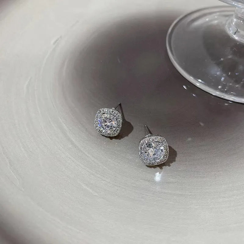 A pair of square-shaped geometric earrings with a diamond treatment detail, shown in a gold colour finish.