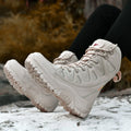 Beige cowhide leather hi-top hiking shoes on a rocky outdoor trail