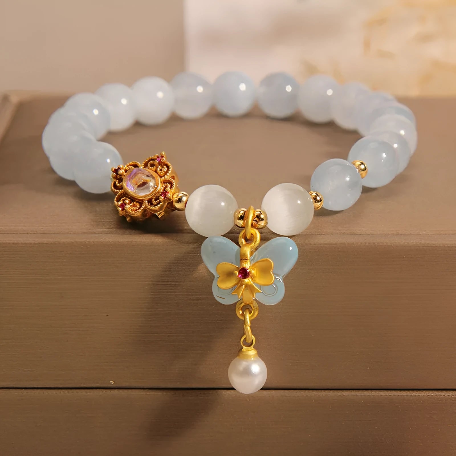Women's crystal bracelet with a blue aquamarine butterfly pendant and sparkling rhinestone details on an adjustable chain.