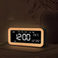 Rectangular blue LED atmosphere alarm clock with digital display on a wooden surface.