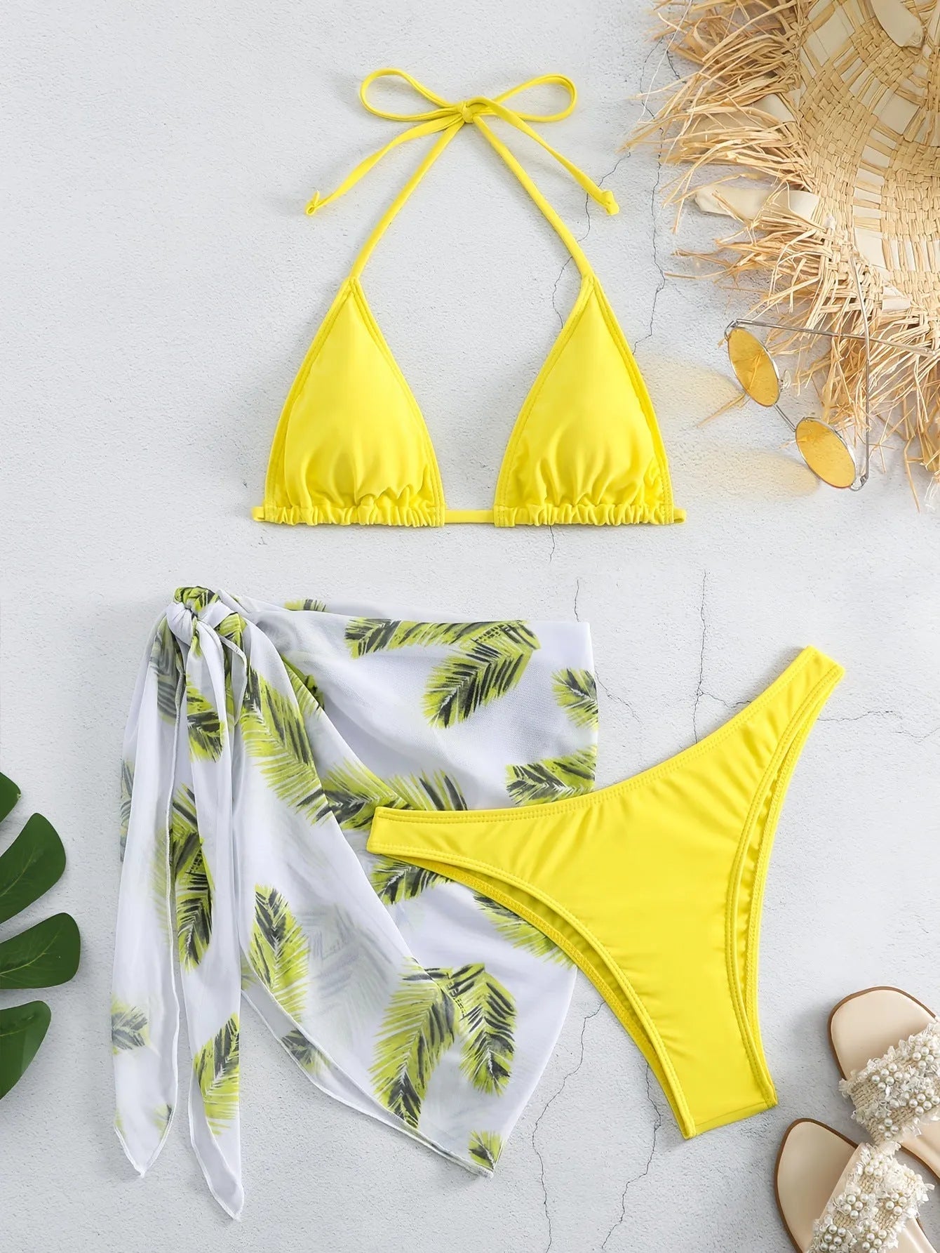 Orange three-piece bikini swimsuit set with a matching printed gauze skirt laid flat.