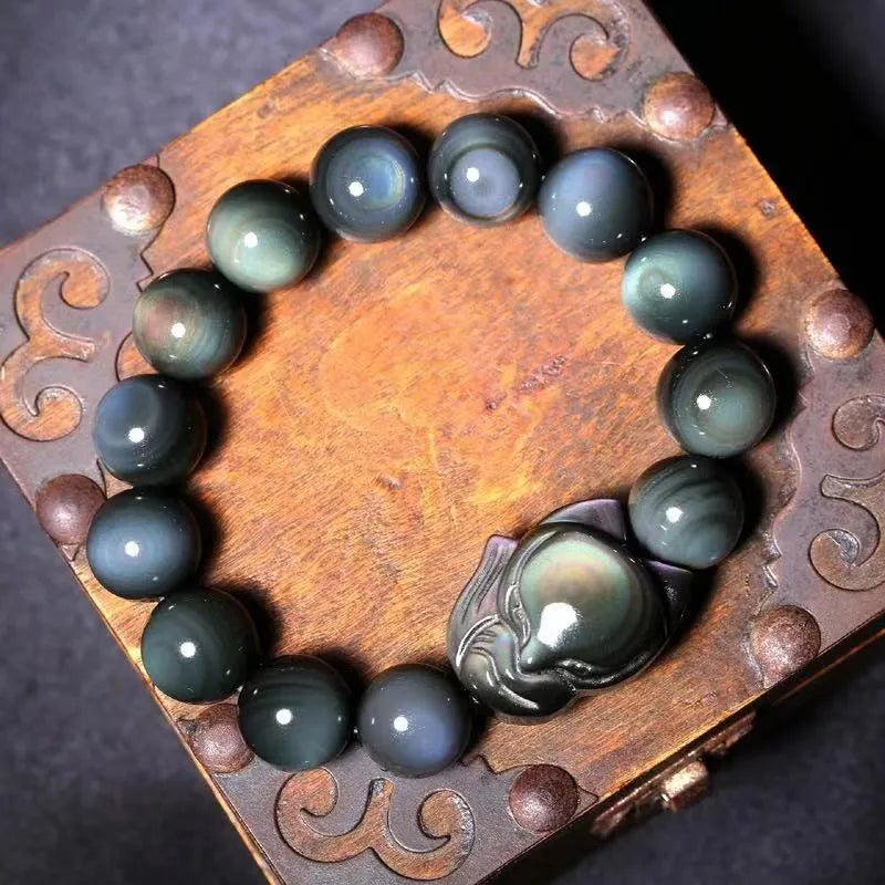 Obsidian stone bracelet with carved fox design on a central bead, shown in multiple size options.
