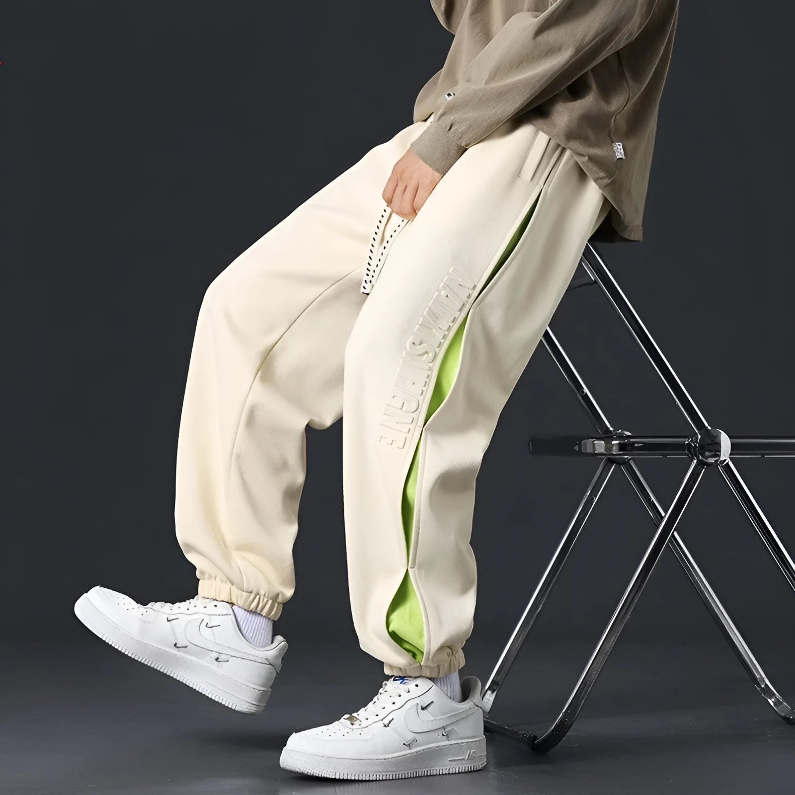 Men's grey green loose-fit cargo trousers with visible stitching detail and a banded ankle opening.