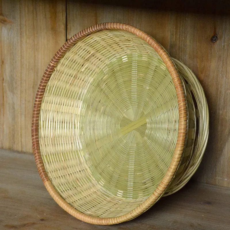 Handmade natural bamboo woven storage basket on a wooden surface.