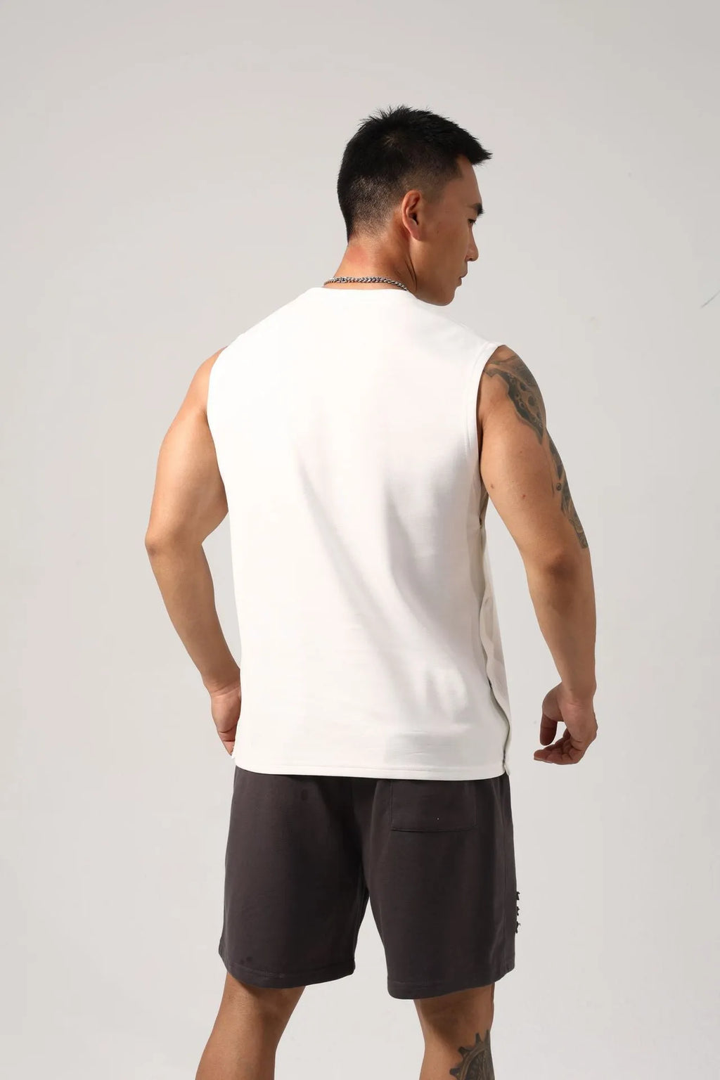 Men's loose black cotton fitness vest showing hidden hook side opening detail.