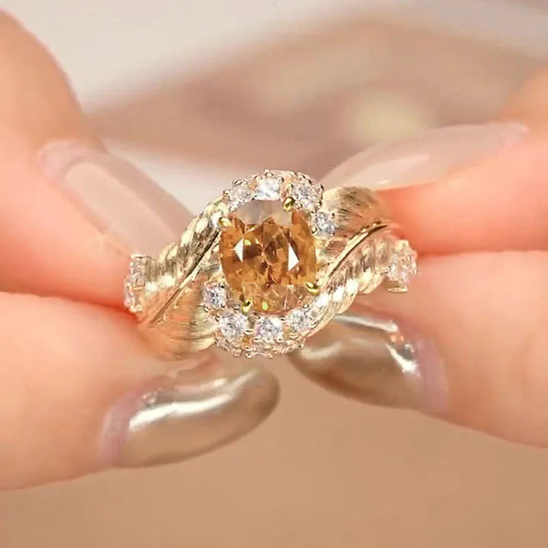 Gold-coloured embossed feather ring with geometric shape and inlaid yellow zircon stone