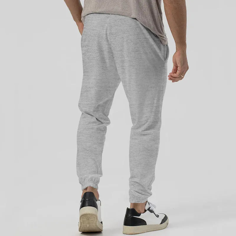 Men's grey casual tapered sweatpants with an elasticated waistband and straight-leg design