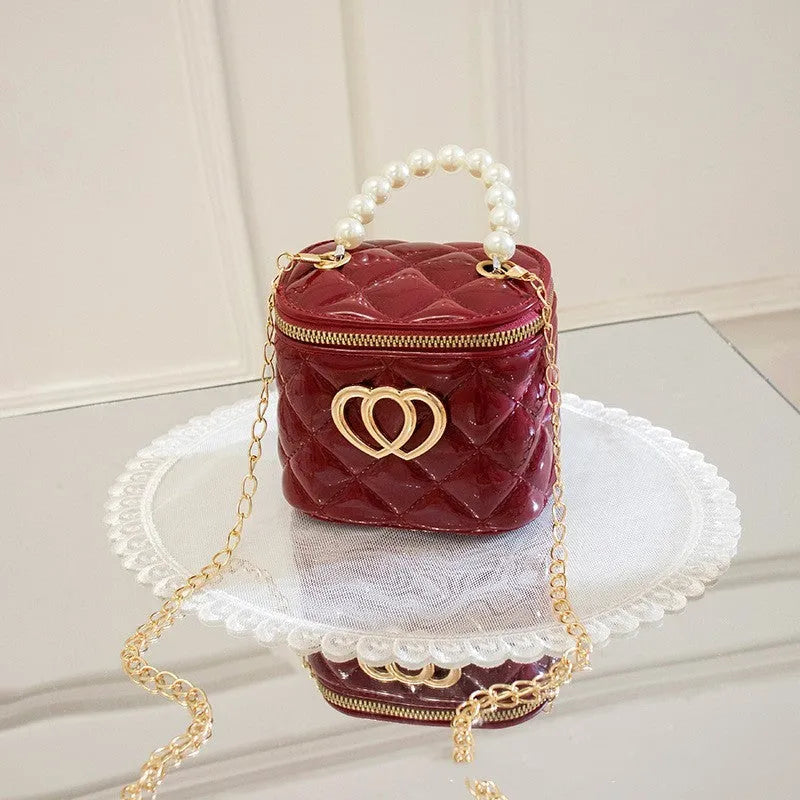 White PVC bucket bag with a red heart pattern, showing its shape and design.