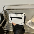 Small square women's crossbody bag in PU leather, shown in street-trend style with a single strap.