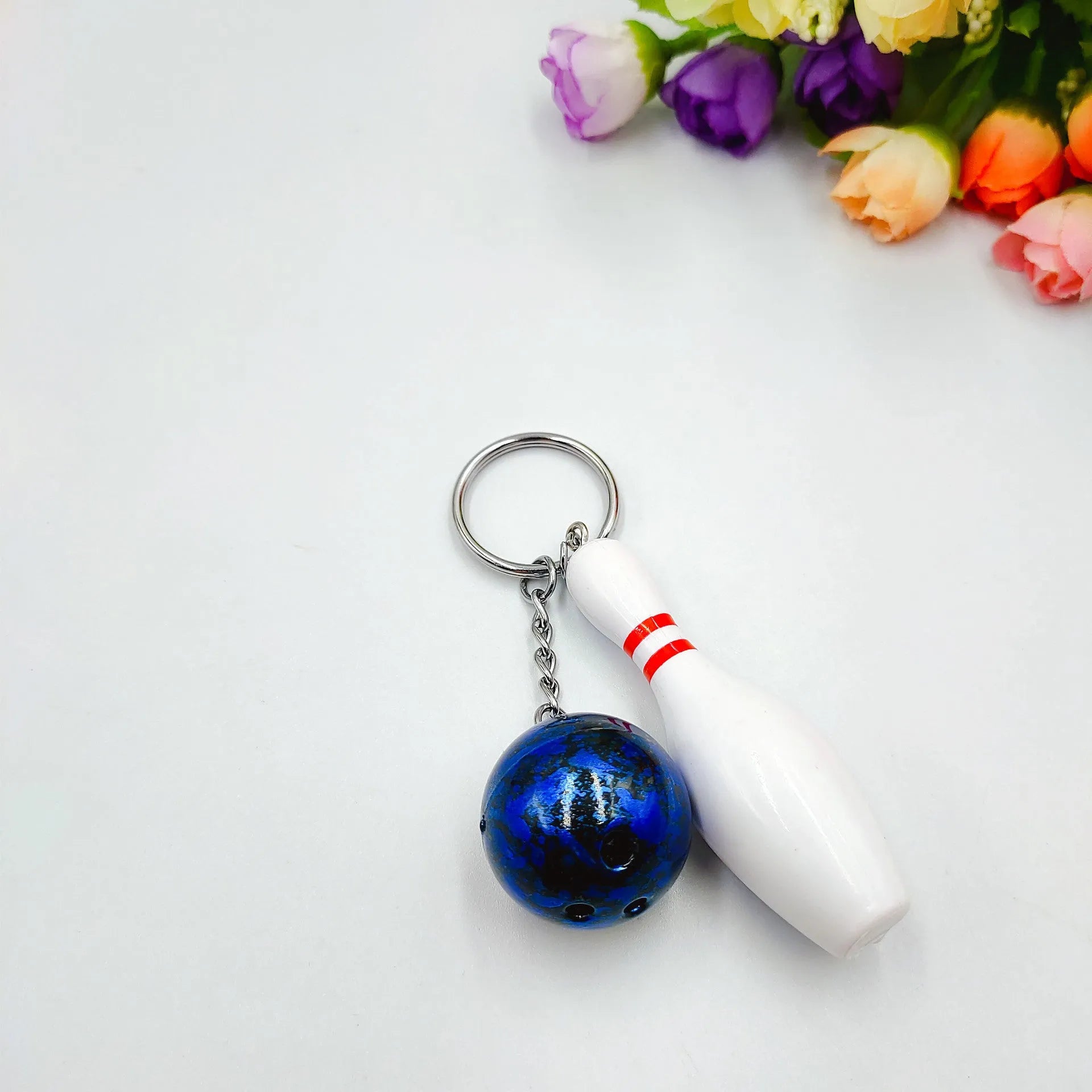 Mini simulation sports bowling ball keychain pendant in dark red, blue, purple, and green colours.