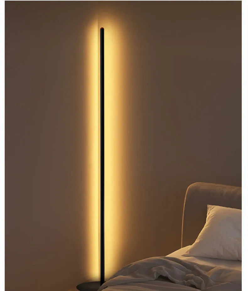 Tall, slim aluminium alloy vertical LED floor lamp standing beside a modern sofa.