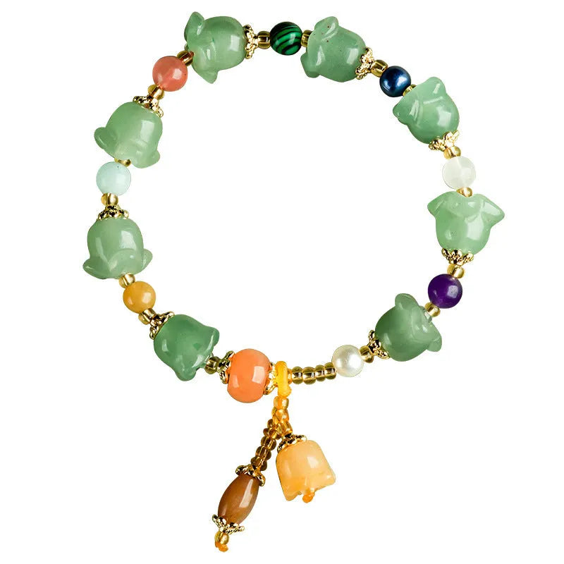 Natural Xinjiang Jinsi Jade bracelet with carved aventurine orchid beads on a wrist.