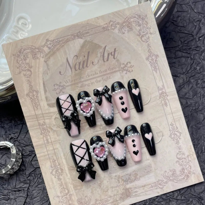 Black and pink heart-shaped hand-painted press-on artificial nails in cat's eye style
